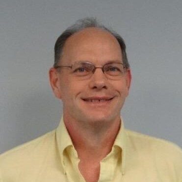 A man with glasses and a yellow shirt